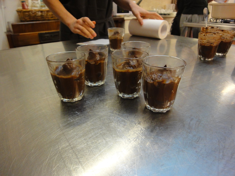 Neatening the mousse glasses before they're garnished and served.