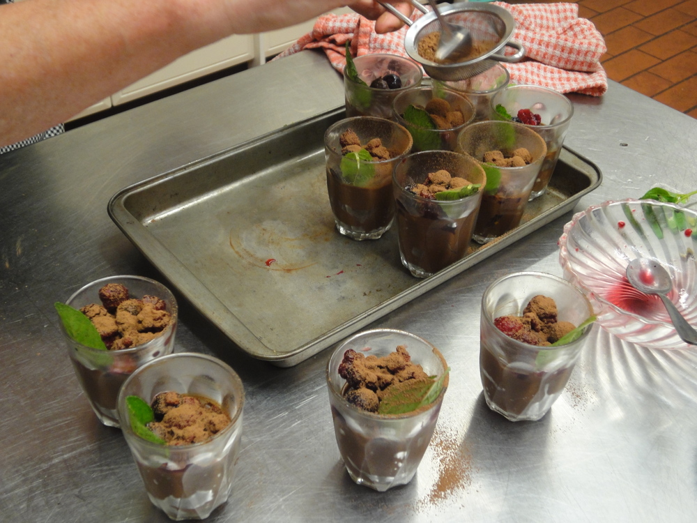 Garnishing our mousse with juicy berries, sprigs of mint and a dusting of cocoa.
