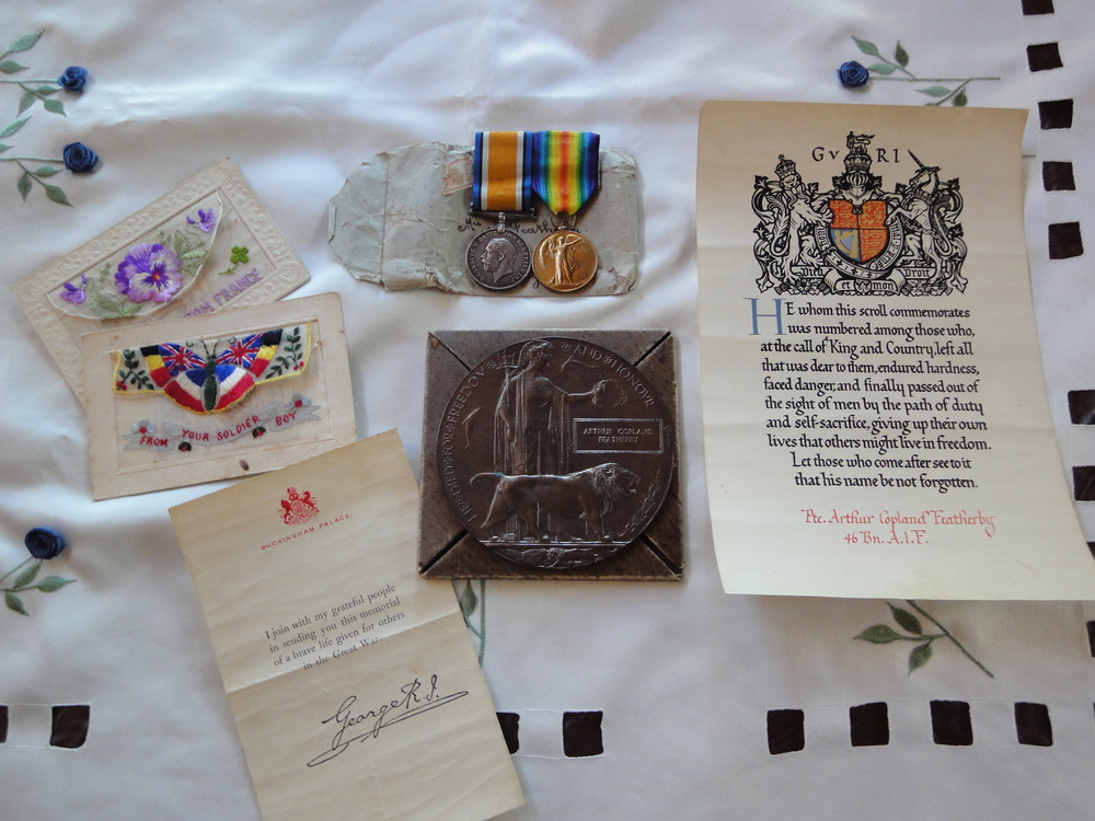 A collection from Arthur's wartime history including a letter from King George V, service medals and postcards he sent home to his family.